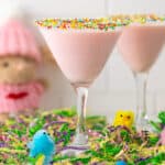 Front view of two pink mocktails in glasses rimmed with Easter sprinkles.